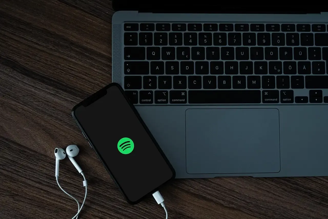 smartphone with spotify and a laptop